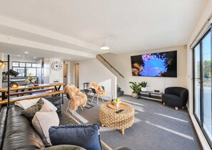 Un salon moderne avec un canapé, une table basse et un téléviseur fixé au mur.
