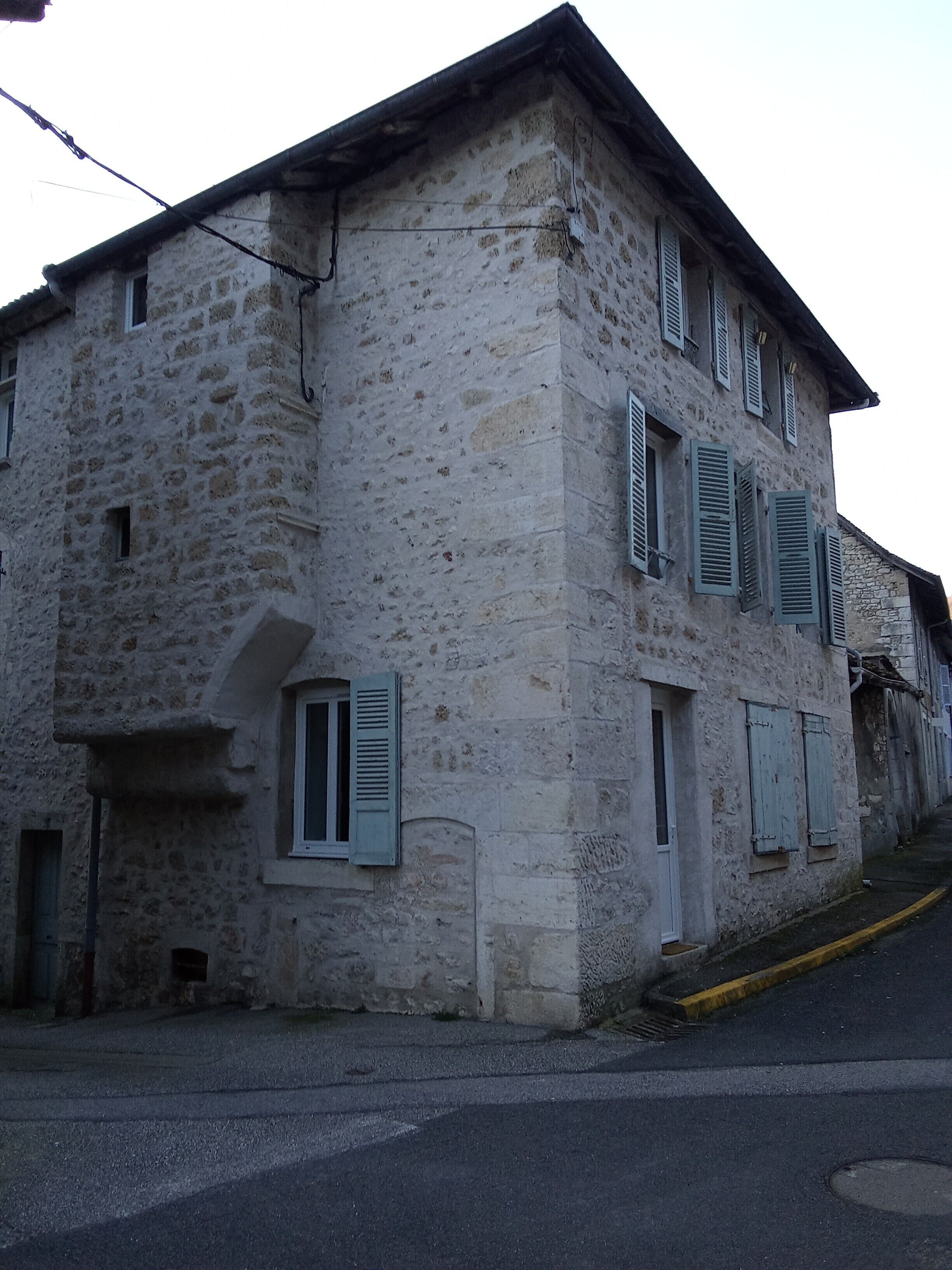Un edificio de piedra con múltiples ventanas y contraventanas.