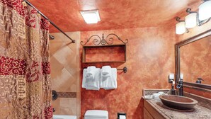 A bathroom with a bathtub, toilet, and sink with a mirror. There is a towel rack with two towels and a shelf above the sink. - Luxury European-Style Penthouse at Copper Mountain (Frisco)