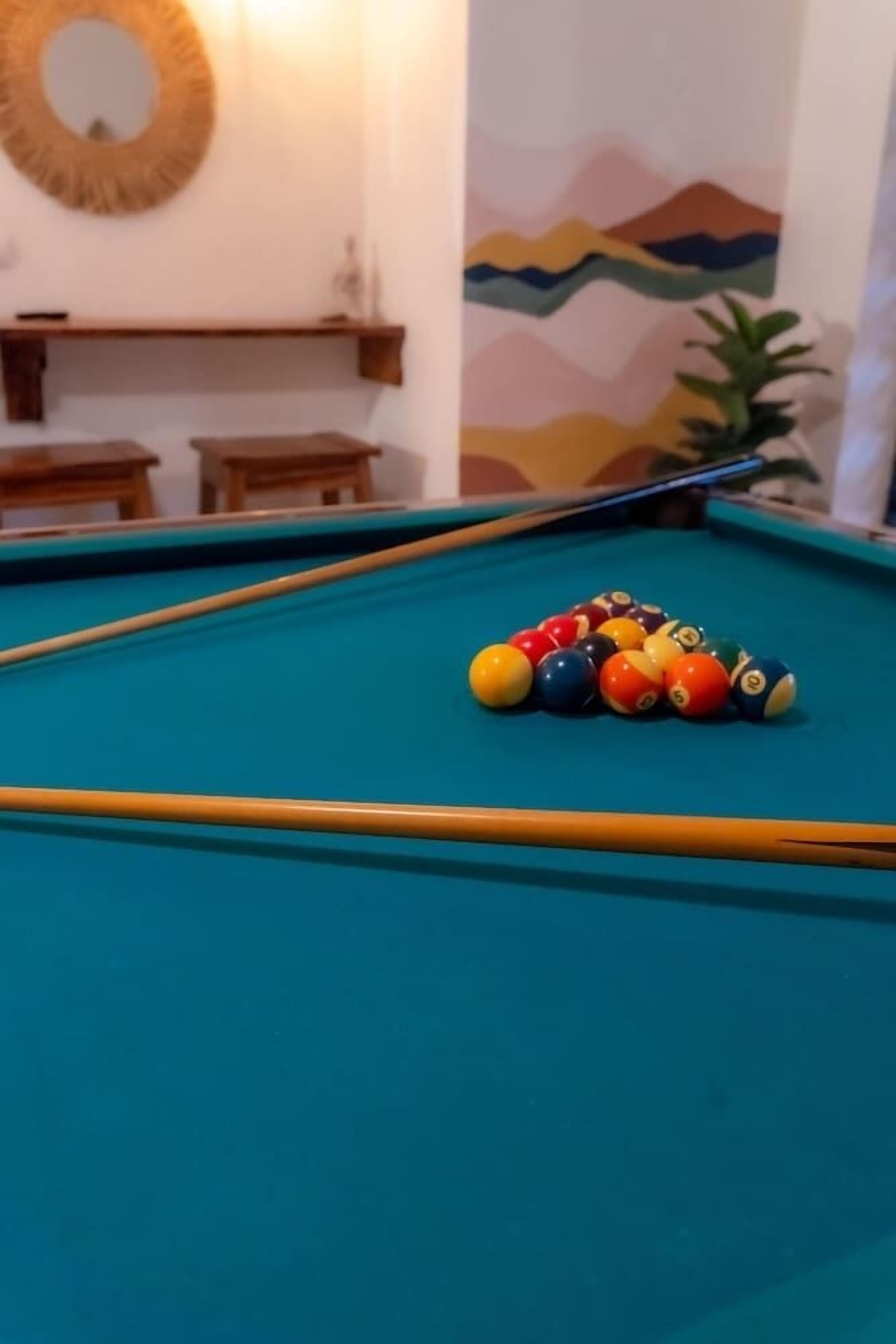 A pool table with a set of billiard balls and a pool cue.