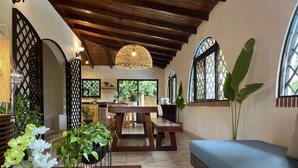 A cozy interior with a wooden ceiling, a dining area, and a seating area with a large window. - 5 min to Beach Private Pool European Style (Sardinal)
