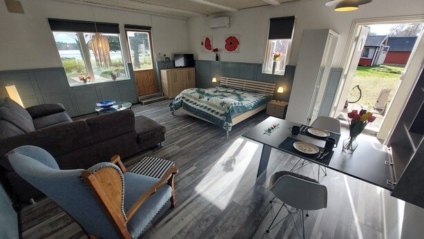 A compact living space with a bed, sofa, dining table, and kitchenette. - Vacation home directly on the Lagan near Markaryd (Markaryd)