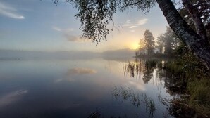 A calm lake with reflections of trees and a clear sky. - Vacation home directly on the Lagan near Markaryd (Markaryd)