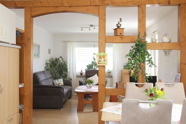 Une pièce comprenant une table à manger en bois, un canapé et un meuble en bois.