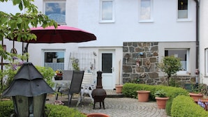 A courtyard with a stone wall, a door, and a window. - Apartment 'Marianne' with Private Terrace and Wi-Fi (Olsberg)