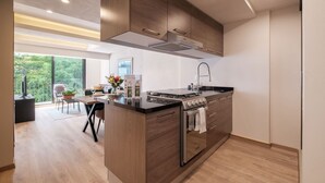 Eine moderne Küche mit Kochinsel, Edelstahlgeräten und Holzschränken.