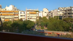 A view of a residential area with multi-story buildings, trees, and a train in the foreground. - Athens City Apartment Petralona Central Gem (Athens)