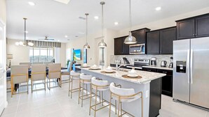 A modern kitchen with a central island, stainless steel appliances, and pendant lighting. - Upstay 7BR Resort Home w Private Pool Near Disney (Davenport)