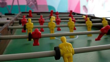 A foosball table with a colorful mural in the background.