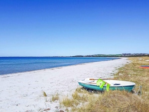 A beach with a boat on the sand and a clear blue sky. - 5 Star Holiday Home in Hojby (Hojby)