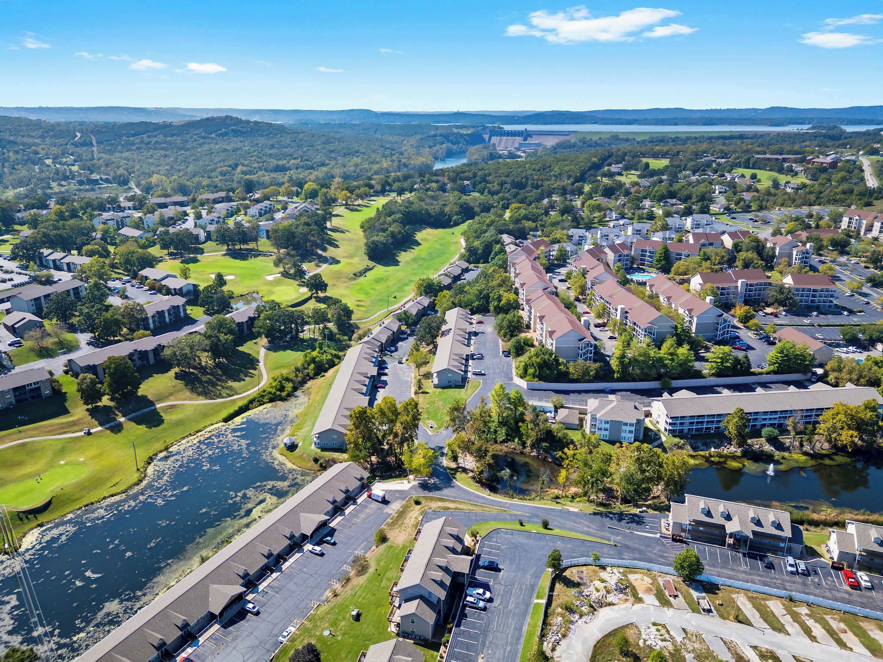 Un quartiere residenziale con palazzi, un campo da golf e un fiume.