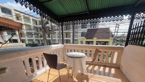 A balcony with a tiled floor, a round table, and two chairs. - Chiang Mai Oasis 2-bedroom Home With Private Entrance & Modern Amenities (Chiang Mai)