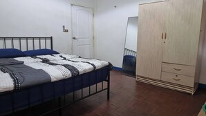 A bedroom with a bed, a wardrobe, and a door. - Chiang Mai Oasis 2-bedroom Home With Private Entrance & Modern Amenities (Chiang Mai)