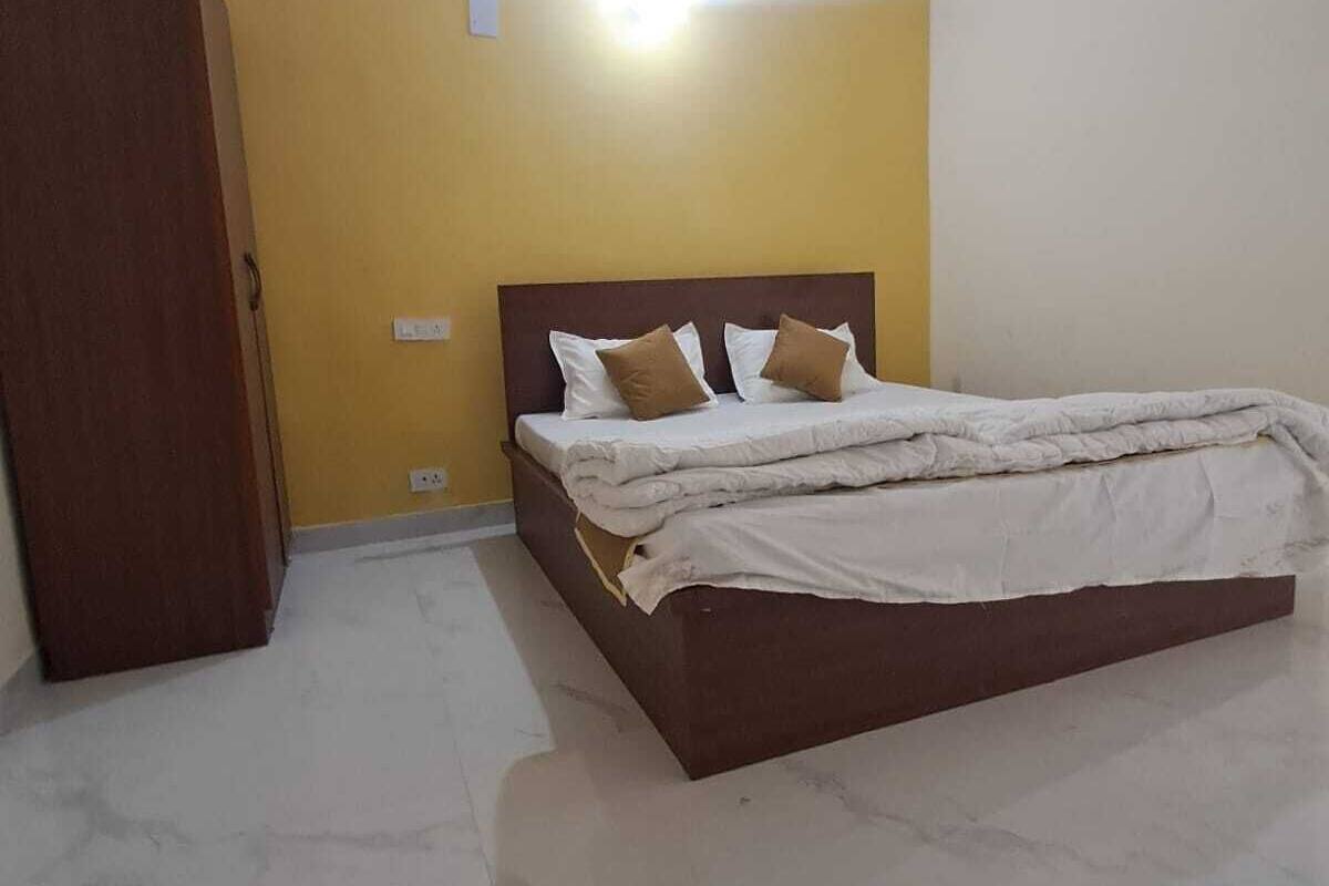 Quarto com cama, guarda-roupa e ventoinha no teto.