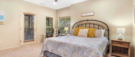 A bedroom with a bed, a ceiling fan, a nightstand, and a window with blinds.