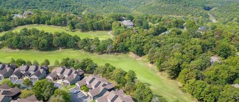A residential area with houses, a golf course, and a parking lot.