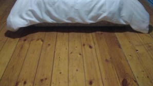 A single bed in a room with blue walls and wooden flooring. - Iceri iki (Baku)