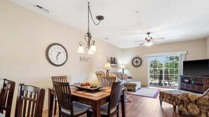 A dining area with a wooden table and chairs, a chandelier, and a clock on the wall. - R&L Scenic Views Retreat for 4 (Branson)