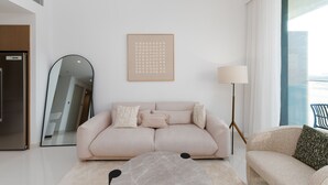 Un salon moderne avec un canapé, une lampe sur pied et un grand miroir.