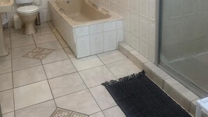 Ein Badezimmer mit Toilette, Waschbecken, Badewanne und Dusche.