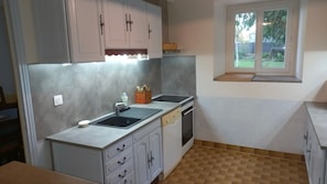 A compact kitchen with a window, a sink, and a dishwasher.