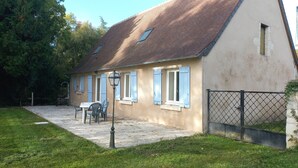 A house with a tiled roof, a small window, and a fenced yard. - Gîte du Moulin de Chanvre with Private Terrace and Garden (Preuilly-sur-Claise)