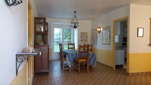 A dining area with a wooden table, chairs, a chandelier, and a cabinet. - Gîte du Moulin de Chanvre with Private Terrace and Garden (Preuilly-sur-Claise)