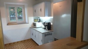 A compact kitchen with a microwave, coffee maker, and a refrigerator. - Gîte du Moulin de Chanvre with Private Terrace and Garden (Preuilly-sur-Claise)