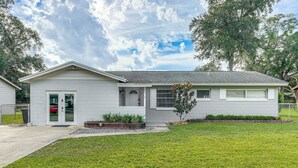 A single-story house with a front door, a small porch, and a well-maintained lawn. - Townhome w/ Fenced Yard in Orlando Suburbs! (Winter Park)