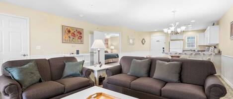 A living room with two brown sofas, a white coffee table, and a ceiling fan.