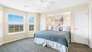 A bedroom with a bed, two windows, a ceiling fan, and a door. - Ozarks Vista Retreat 6ppl Stay (Kimberling City)