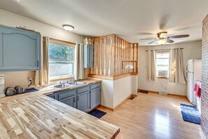 Een moderne keuken met houten kasten, een groot eiland en een plafondventilator.
