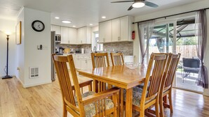 A modern kitchen with white cabinets, a wooden dining table, and chairs. - Explore Camano Island Beaches! Family Home w/ Yard (Stanwood)