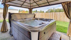A hot tub under a pergola with a wooden fence in the background. - Explore Camano Island Beaches! Family Home w/ Yard (Stanwood)