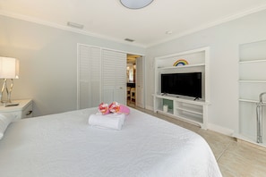 A hotel room with a large bed, a television, and a bathroom visible through an open door. - Walkable Island City Oasis w/ Private Heated Pool! (Wilton Manors)