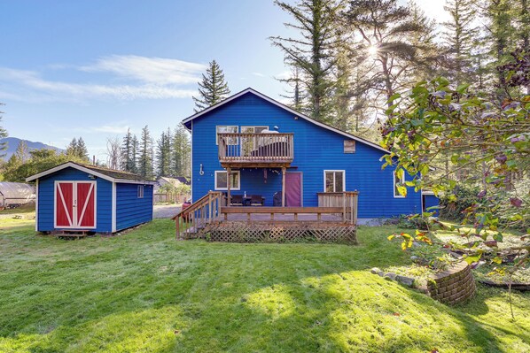 Ein blaues Haus mit Balkon und kleiner Gartenlaube.