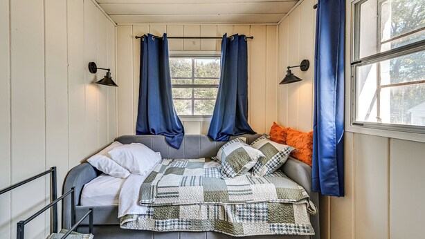 Una camera accogliente con un letto, tende e una finestra.