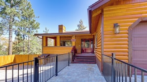 A log cabin with a wooden exterior, a staircase leading to a porch, and a fenced driveway. - Big Bear Mtn Fun: Family Cabin w/ Game Room (Sugarloaf)