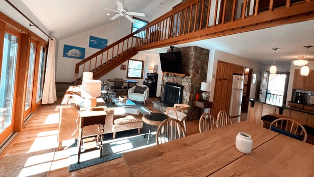 A spacious living room with a high ceiling, a fireplace, a dining area, and a kitchen. - The Magic Teacup:  Steps from the Slopes and Trails! (Davis)