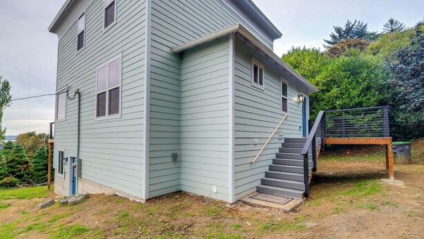 Ein zweistöckiges Haus mit Veranda und einer Treppe, die zum zweiten Stock führt.
