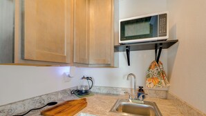 A kitchen with a microwave, sink, wooden cutting board, and a kettle. - Pet-friendly Farmhouse Suite w/ Patio in Vaughn! (Vaughn)