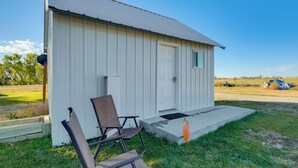A small, single-story building with a white exterior and a sloped roof. - Pet-friendly Farmhouse Suite w/ Patio in Vaughn! (Vaughn)