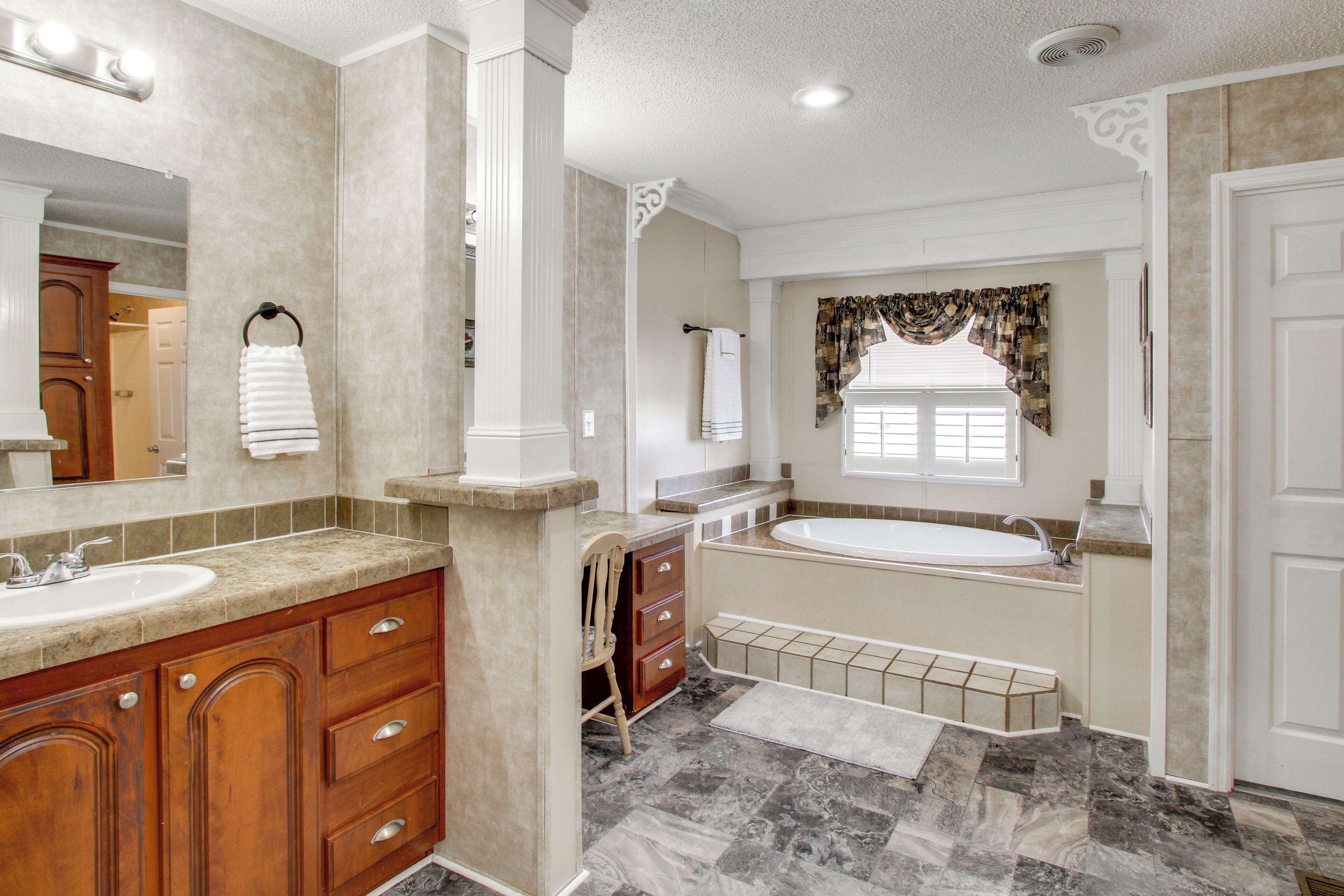 A bathroom with a large sink, vanity, and bathtub.