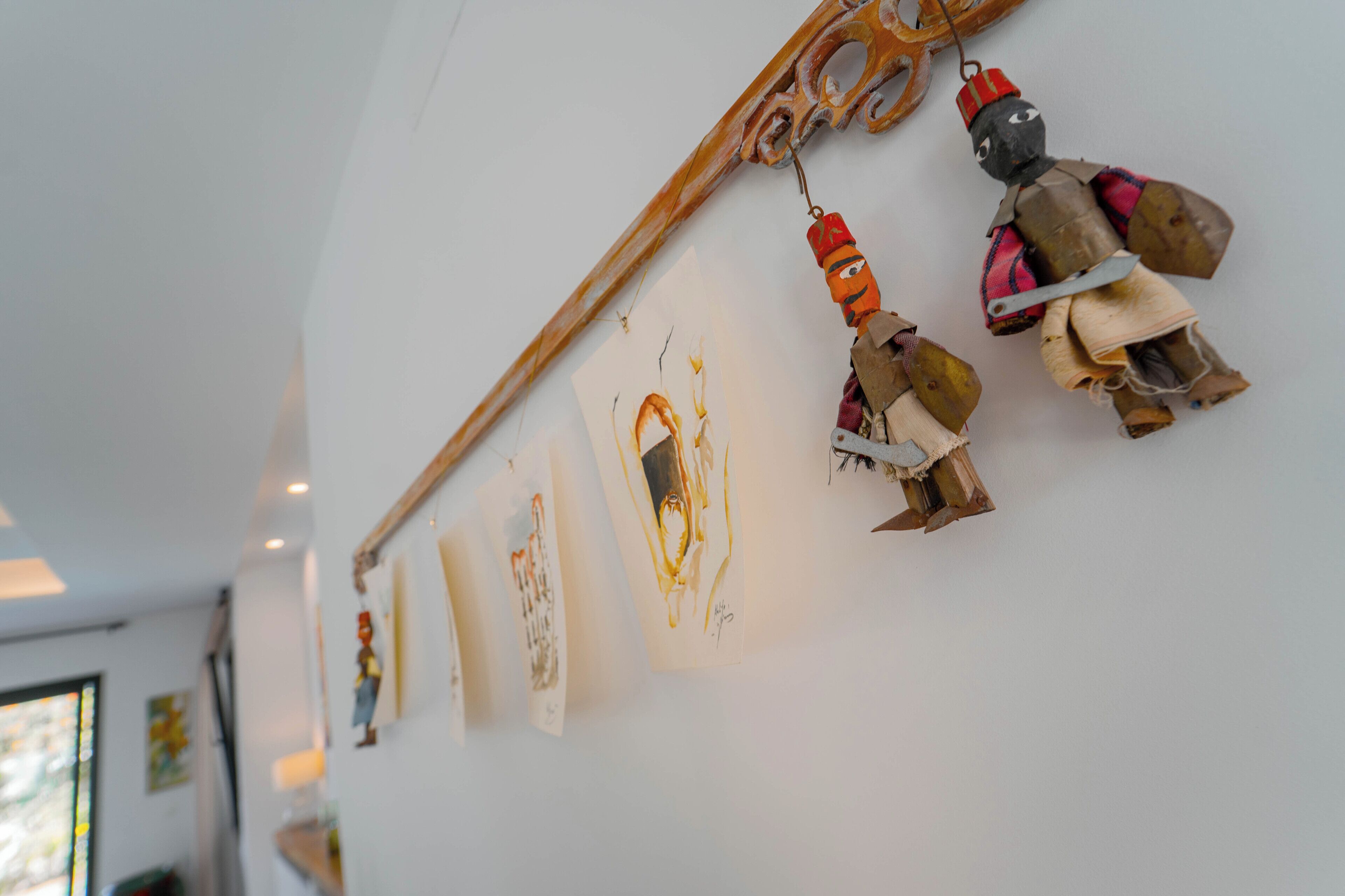 Eine Wand mit verschiedenen Kunstwerken und einer Holzkonstruktion.