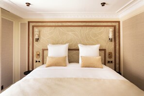 Una habitación de hotel con una cama grande, dos mesitas de noche y un cabecero decorativo.