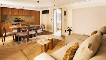 A modern living room with a sofa, a coffee table, and a dining area with chairs and a table.