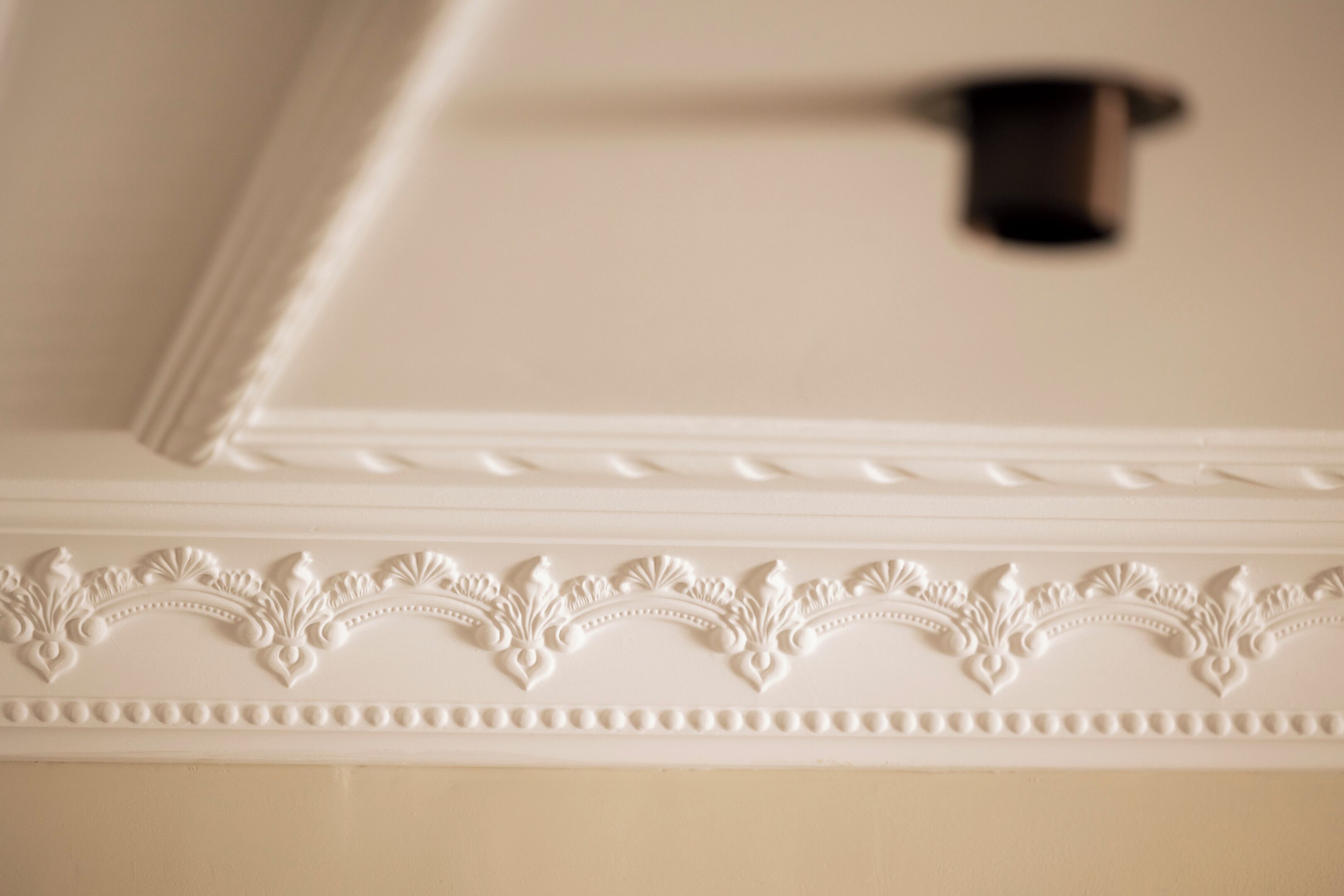 A ceiling with decorative molding and a recessed area.