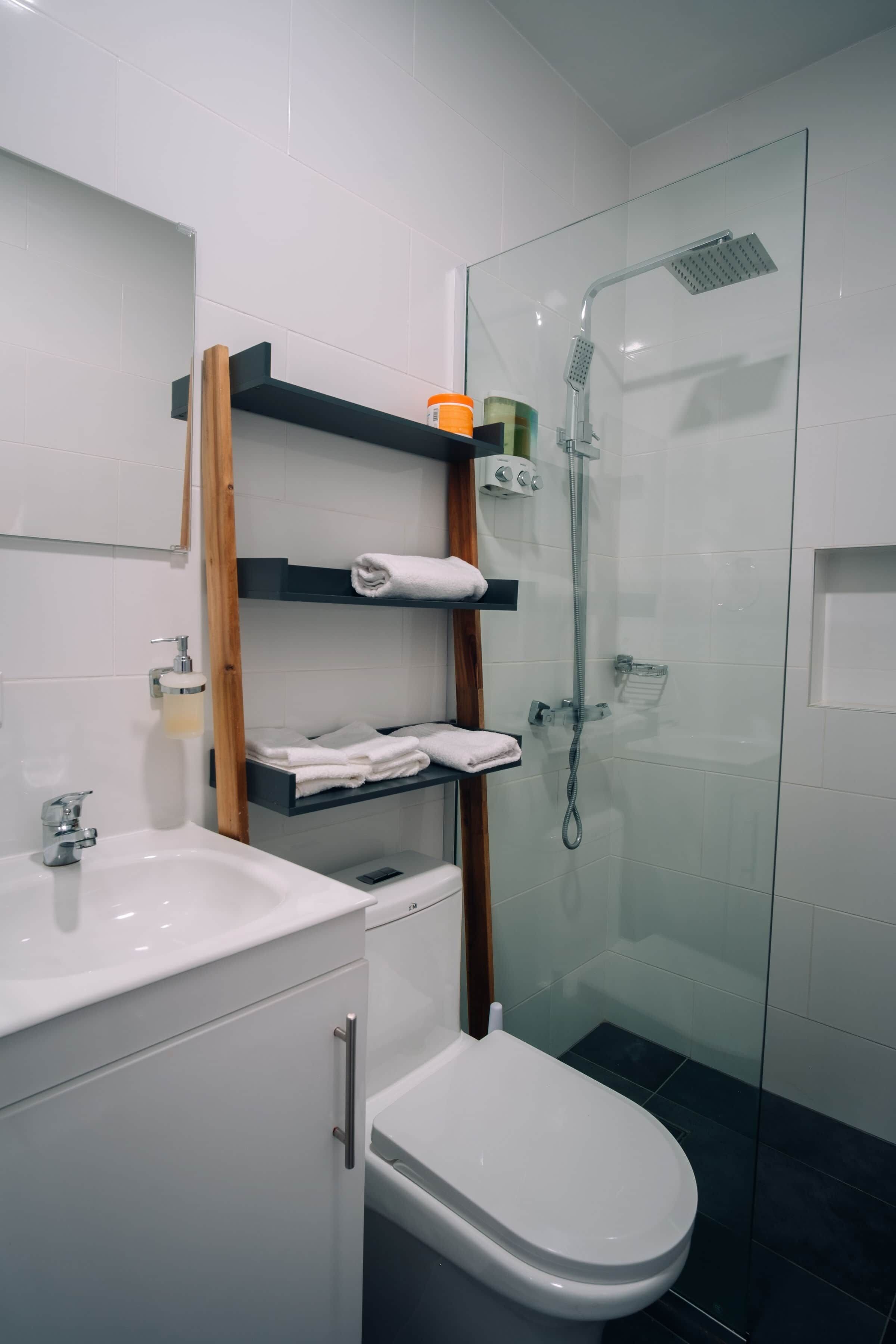 Ein modernes Badezimmer mit Duschkabine aus Glas, einem weißen Waschbecken und einer Toilette.