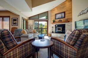 Una sala de estar acogedora con muebles de cuadros, una chimenea y una vista panorámica.