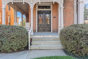 A brick building with a double door and a covered porch.